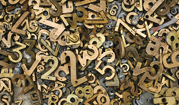 brass three dimensional numbers in a large pile photo