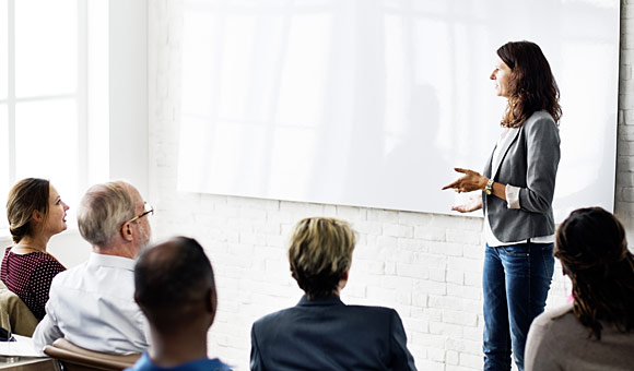 closeup contemporary office interior with woman in front of white board speaking to co-workers photo