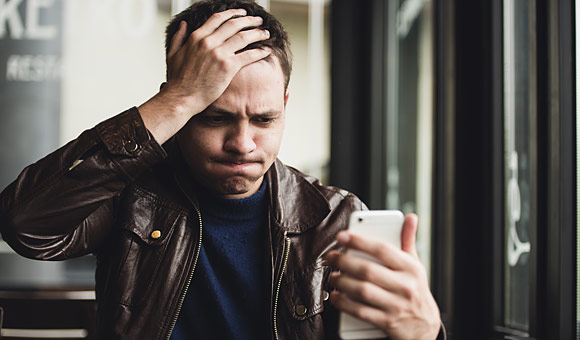 frustrated man looking at phone